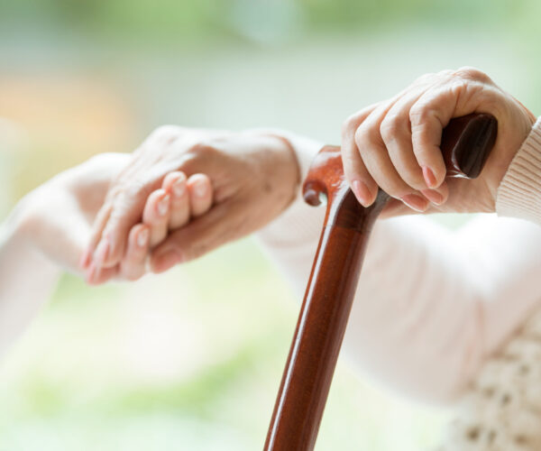 Hand van oude vrouw wordt vast gehouden