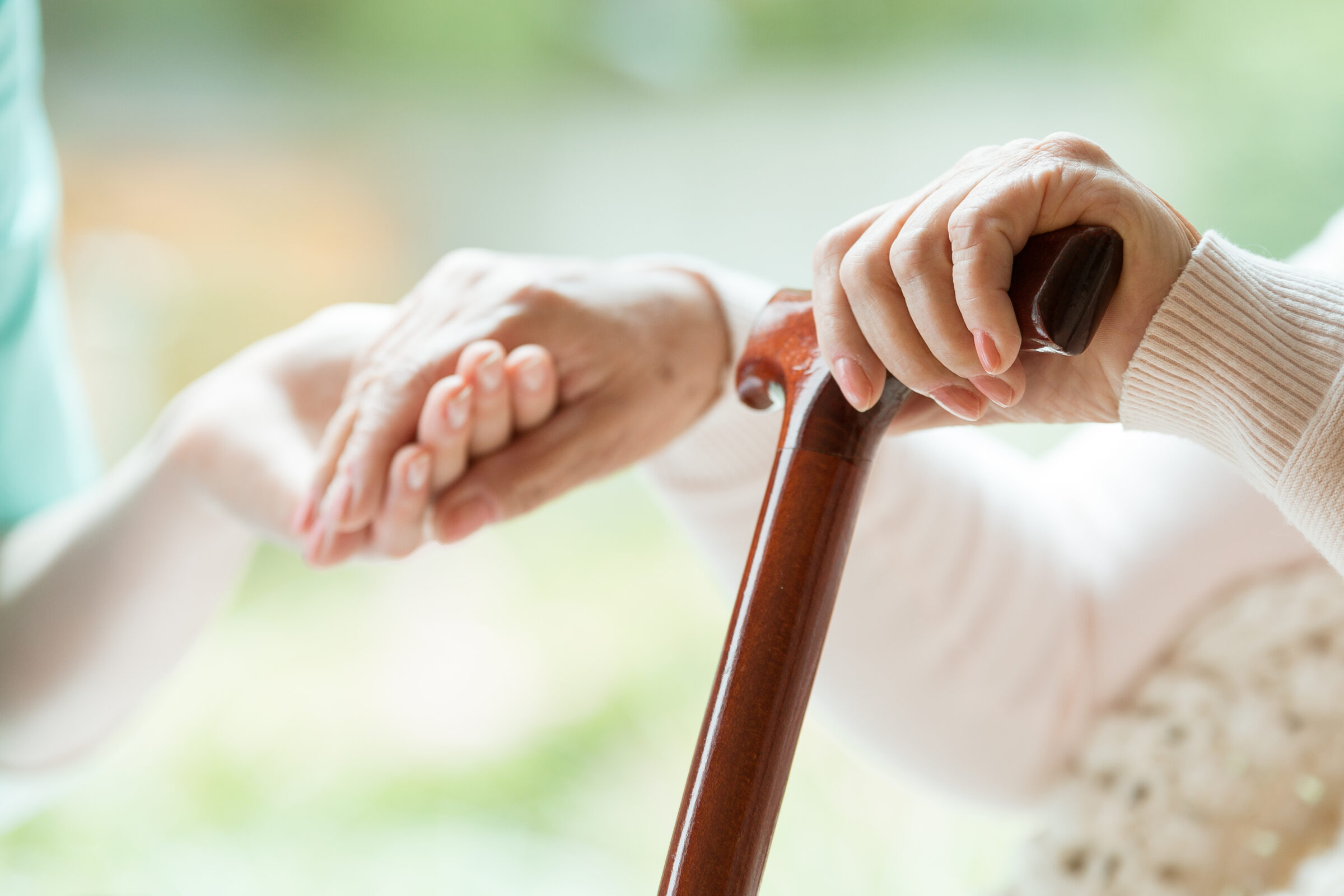 Hand van oude vrouw wordt vast gehouden